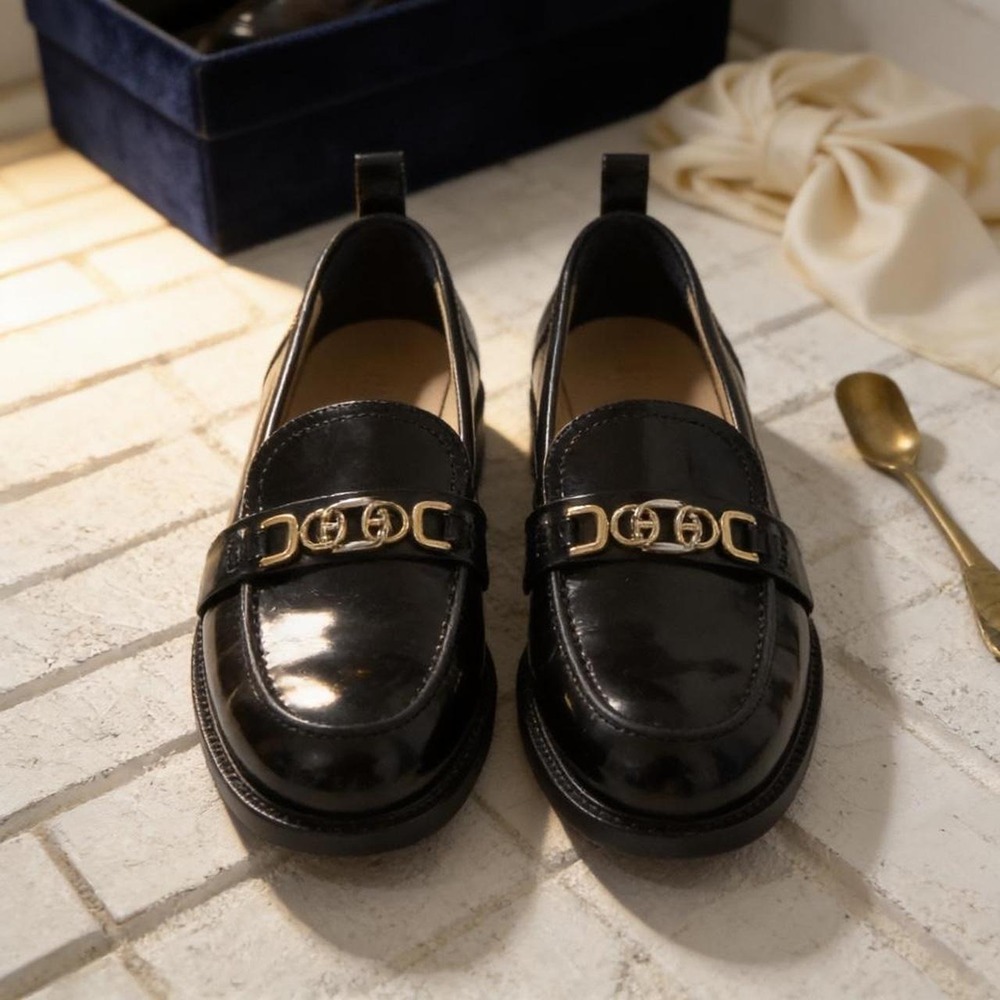 Black leather loafers with gold hardware